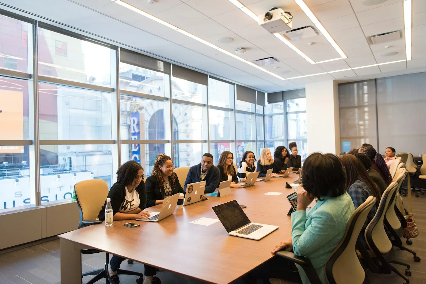 A team of colleagues around a table with laptops, working through a plan together